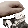 a hand is holding a cartoon character 's head .