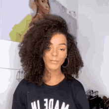a woman with curly hair is wearing a black shirt that says " wide " on it
