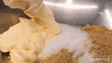 a person is pouring mayonnaise into a bowl filled with sugar and nuts .
