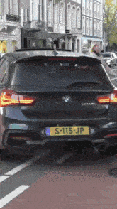 a black bmw with a license plate that says s-115-jp