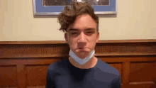 a young man wearing a mask is making a funny face