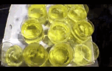 a bunch of glasses filled with yellow liquid are sitting on a table