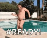 a man in a bikini is jumping into a swimming pool .