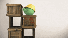 a green pig wearing a yellow hard hat stands on top of a stack of wooden crates