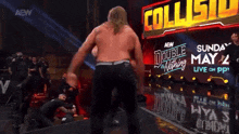 a wrestler is standing in front of a sign that says collisio
