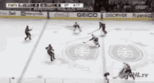 a hockey game is being played on a rink with advertisements for geico