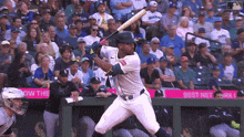 a baseball player getting ready to swing his bat in front of a crowd that is watching