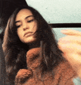 a woman with long hair is wearing a teddy bear jacket
