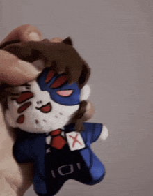 a person is holding a stuffed animal with an x on the chest