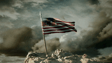 an american flag with a lion on it is flying on top of a rocky hill