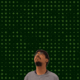 a man stands in front of a green background with the number 20 and 4