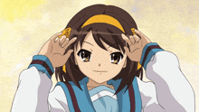 a girl with brown hair and a yellow headband is making a peace sign