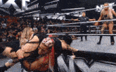 a female wrestler is carrying another wrestler in a wrestling ring while a referee watches