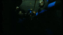 a group of people wearing blue gloves are posing for a picture in a dark room