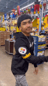 a man wearing a black sweatshirt with the letter s on it