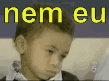 a young boy is making a funny face in front of the word nem eu .