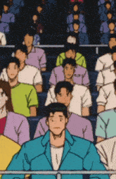 a group of people are sitting in a stadium and one man is wearing a blue jacket