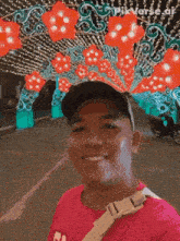 a man in a pink shirt is smiling in front of a sign that says pixverse.ai