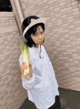 a woman wearing a helmet and holding a bunch of greens