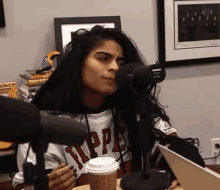 a woman is sitting in front of a microphone wearing a shirt that says tipper