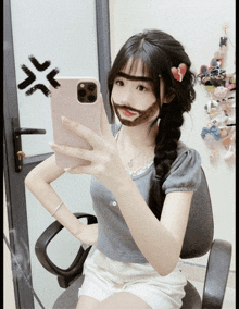 a girl is taking a selfie with her phone and has a beard on her face