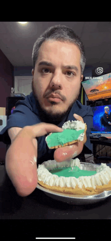 a man is holding a piece of pie in front of a tv screen that says alienware