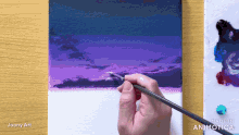 a person is painting a purple sky with a brush and the words made in animatica on the bottom