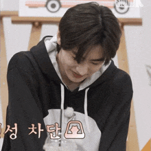 a young man wearing a black hoodie with a white bunny on it