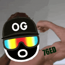 a man wearing sunglasses and a hat with og on it flexes his muscles