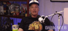 a man sitting in front of a microphone wearing a shirt that says dark web on it
