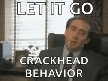 a man in a suit and tie is smoking a cigarette in an office .