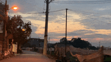 a street with a sunset in the background and a street light
