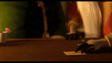 a person is writing on a piece of paper on a wooden table