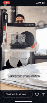 a man holding a box that says let 's pack some orders on it