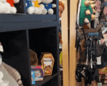 a shelf full of stuffed animals including a box that looks like a mummy