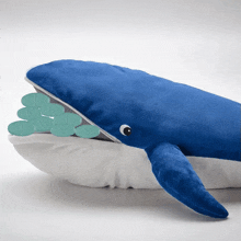 a stuffed whale with pills in its mouth including the numbers 1 2 3 4 5 6 7 8 9 and 10