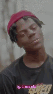 a man wearing a red beanie and a black speed shirt