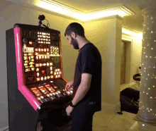 a man wearing a black shirt that says zfr stands in front of a slot machine
