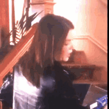 a woman is sitting on a staircase looking down at something