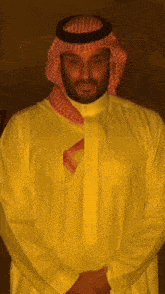 a man with a beard wearing a yellow shirt and a red scarf