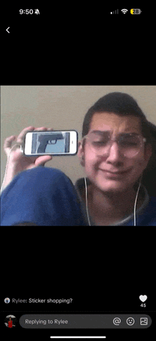a man holding up a cell phone with a gun on it