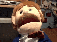a puppet with a mustache and a bow tie is sitting in front of a dvd player that says ' 000 ' on it