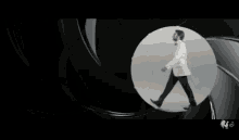 a man in a tuxedo is dancing in front of a camera lens