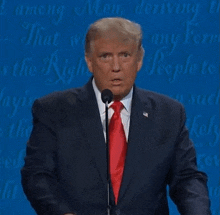 donald trump is speaking into a microphone in front of a blue background that says " among men "