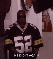 a man wearing a football jersey and sunglasses is standing in a hallway .