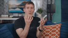 a man sitting on a couch wearing a shirt that says ' chat ' on it