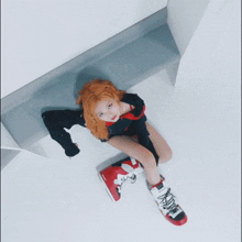 a woman with red hair is laying on the floor with a pair of red and white boots on her feet