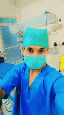 a surgeon wearing a mask and a cap takes a selfie in an operating room