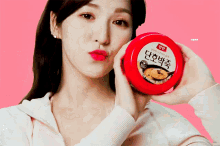 a woman holds a red container with a spoon in it