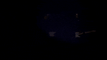 a dark room with a few lights shining through a hole in the wall